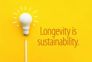 Light bulb above a pencil on a yellow background, symbolising an idea focused on durability, design intention, and product longevity as a sustainability strategy.